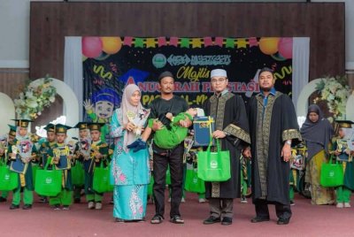 Mohd Faizal (dua dari kiri) bersama isteri, Siti Norazilla ketika mendukung Muhammad Aish menerima sijil sempena majlis anugerah prestasi Pusat Asuhan Tunas Islam (PASTI) Al-Mukmin Sabtu lalu. Foto Jabatan PASTI Negeri Terengganu