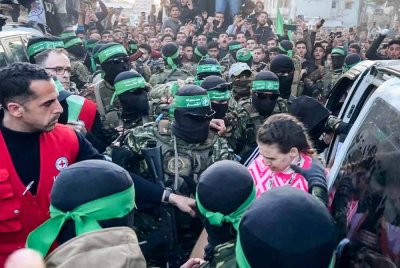 Tebusan Israel dibebaskan pejuang Hamas keluar dari sebuah kenderaan untuk diserahkan kepada Jawatankuasa Palang Merah Antarabangsa (ICRC) susulan perjanjian gencatan senjata pada pagi Ahad. - Foto AFP