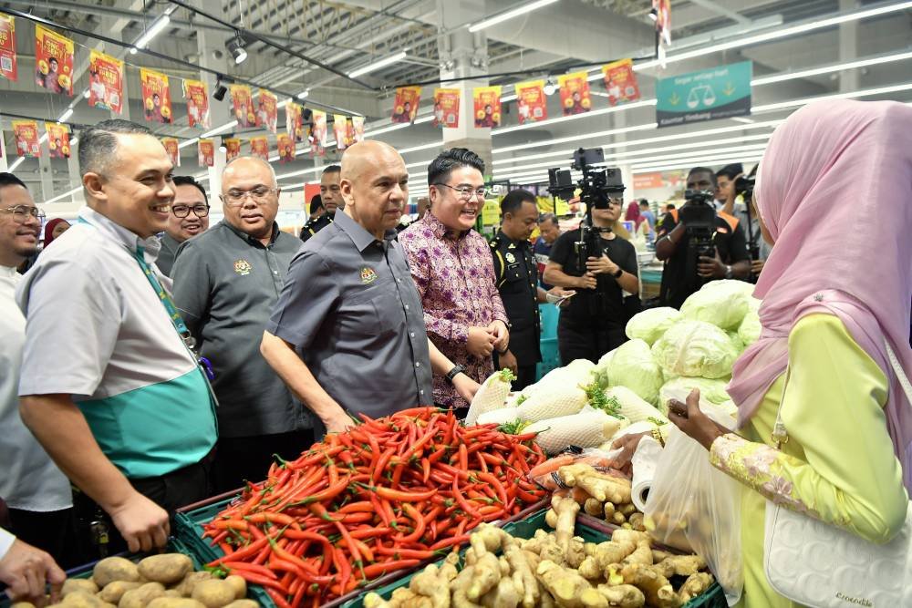  Armizan (tengah) menyantuni orang ramai ketika meninjau harga barangan pada Pelancaran Program Jualan Rahmah Madani Dan Pengumuman Skim Harga Maksimum Musim Perayaan Tahun Baharu Cina 2025 di Pasar raya Lotus’s Teluk Intan pada Selasa. Foto Bernama
