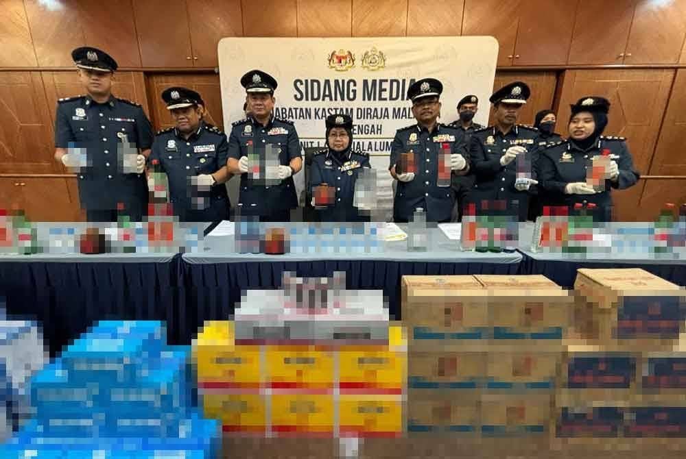 Norlela (tengah) menunjukkan minuman keras dan produk minuman tenaga bergula yang dirampas.