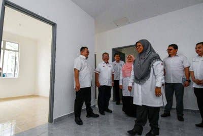 Aiman Athirah (tiga, kanan) meninjau keadaan rumah pada Majlis Penyerahan Surat Tawaran bagi Program Perumahan Rakyat (PPR) Gual Ipoh pada Isnin.