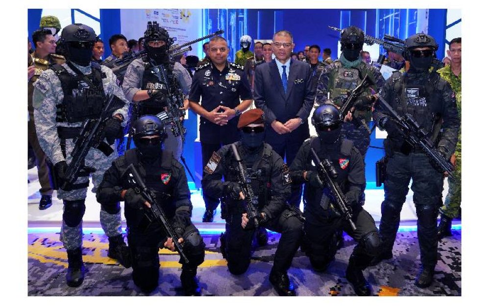 Menteri Dalam Negeri, Datuk Seri Saifuddin Nasution Ismail (berdiri, empat dari kiri) bergambar bersama pasukan polis ketika melawat ruang pameran AISSE'25 di PICC pada Selasa.