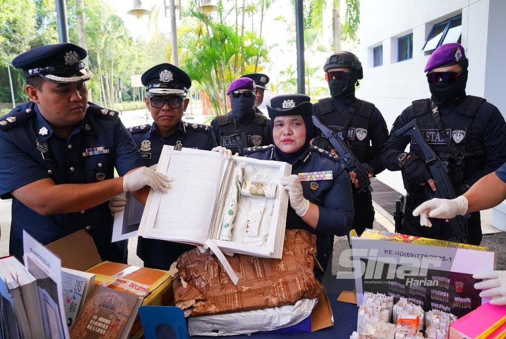 Raizam (tiga dari kiri) menunjukkan buku yang dilubangkan bagi menyorokkan dadah kokain sebelum diseludup keluar negara. Foto MOHD HALIM ABDUL WAHID