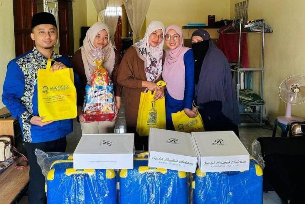 WAKIL Andalusia Kuantan menyerahkan kelengkapan umrah kepada Faridah (tengah) selepas Ibrahim menyatakan hasratnya untuk menghadiahkan pakej umrah melalui panggilan video pada Isnin. 