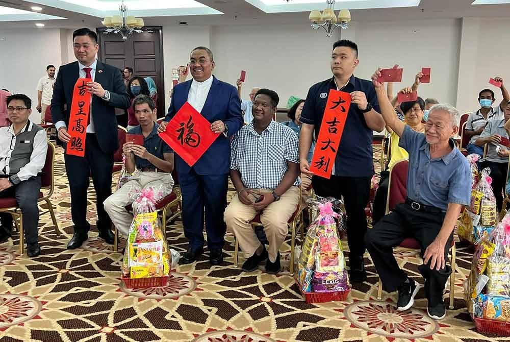 Sanusi (tengah) bersama Chia Zhen (kiri) meraikan penerima sumbangan Tahun Baharu Cina di Wisma Darul Aman pada Rabu.