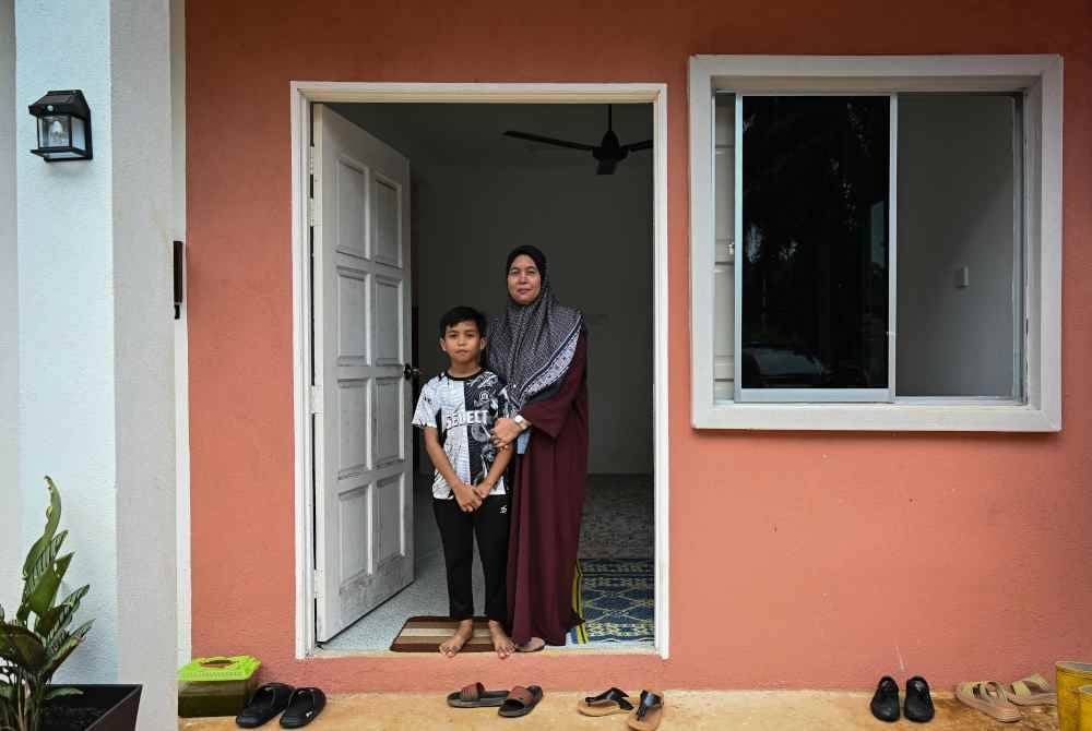Ibu mangsa, Ruziah Fuad, 47, (kanan) bersama anaknya, Aqib Aisy Azman, 11, semasa ditemui di Kampung Bukit Apit pada Rabu. Foto Bernama