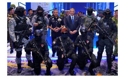 Menteri Dalam Negeri, Datuk Seri Saifuddin Nasution Ismail (berdiri, empat dari kiri) bergambar bersama pasukan polis ketika melawat ruang pameran AISSE'25 di PICC pada Selasa.