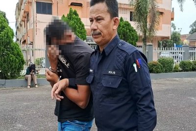 Suspek (kiri) dibawa ke Mahkamah Kemaman bagi perintah sambungan reman sehingga Jumaat.