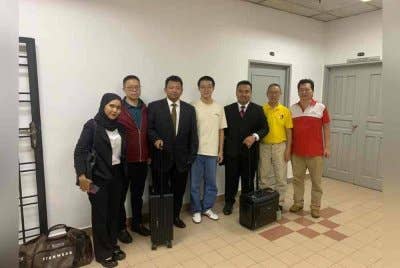 Xiaonan (empat dari kanan) tersenyum apabila dilepaskan sementara dengan jaminan sebanyak RM8,000 oleh Mahkamah Majistret Johor Bahru pada Isnin.