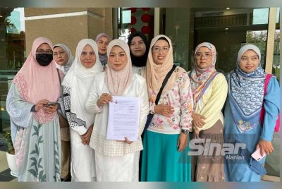Ena (tiga dari kiri, depan) bersama beberapa jemaah umrah yang terkandas menunjukkan memorandum terbuka di bangunan MOTAC, Putrajaya pada Rabu.