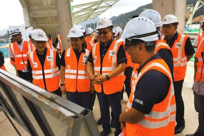 Ahmad Samsuri (tengah) mendengar penerangan ketika melawat kawasan Pembangunan Berorientasikan Transit (TOD) di stesen Projek Laluan Rel Pantai Timur (ECRL) Dungun, pada Rabu.