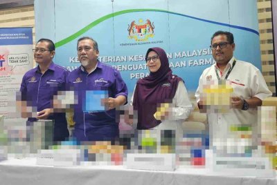 Mohd Zawawi (dua dari kiri) menunjukkan produk-produk kesihatan yang dirampas dalam serbuan Op Pharma 2.0 dan Op Gudang, Jabatan Kesihatan Negeri (JKN) Perak pada Selasa.