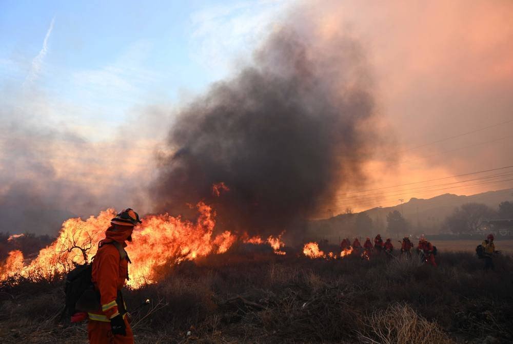 Asap dari kebakaran Hughes memenuhi langit di Castaic, sebuah kawasan di barat laut Daerah Los Angeles, California. Foto AFP