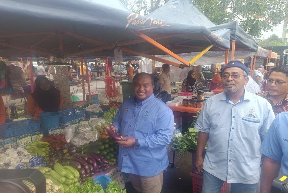 Muhamad Fadlee (kiri) melakukan tinjauan di sebuah gerai di pasar tani.