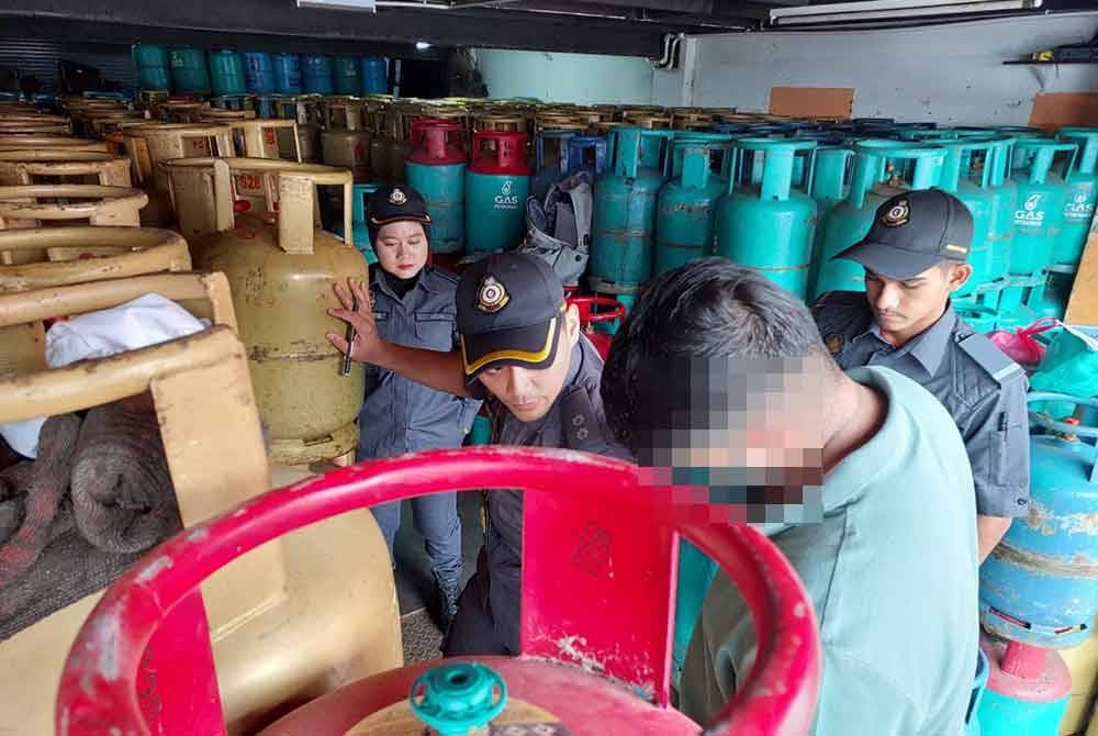 Pegawai KPDN menjalankan pemeriksaan tong gas LPG ditemukan dalam serbuan di sebuah kedai runcit di ibu kota pada Selasa.