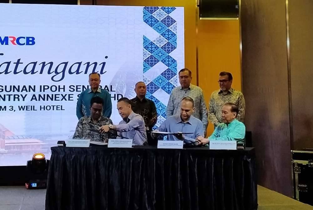 Anthony Loke (berdiri, dua dari kanan) dan Saarani (dua dari kiri) menyaksikan Majlis Menandatangani Memorandum Perjanjian Pembangunan Ipoh Sentral di sebuah hotel pada Khamis.