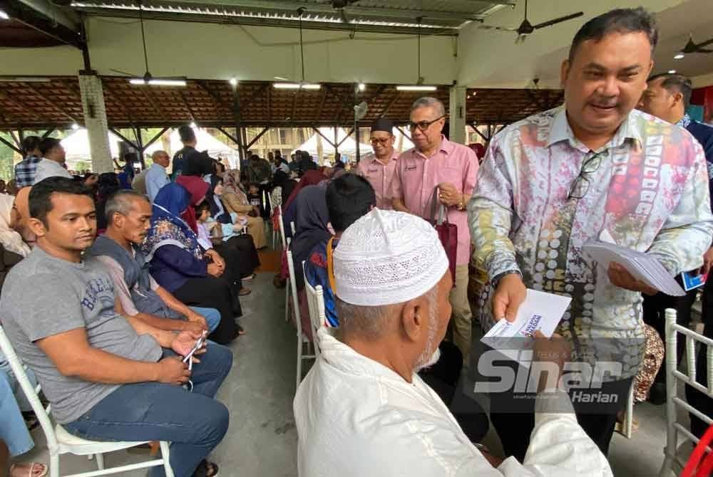 Azman (berdiri) menyampaikan sumbangan pada Program Bantuan One Off Perdana Menteri anjuran bersama Pertubuhan Masyarakat Madani Gaul Ipoh (MMGI) di Tanah Merah pada Khamis.