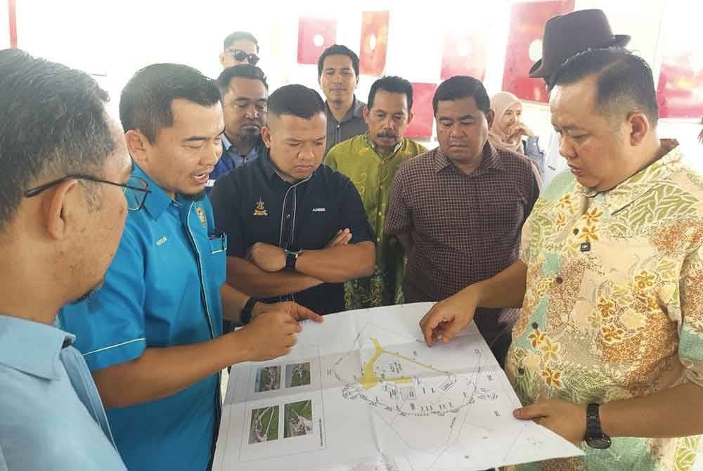 Rizam (kanan) bersama-sama agensi terlibat melihat pelan pembangunan daerah Sabak Bernam di Bagan Nakhoda Omar pada Khamis.