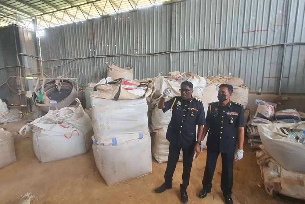 Jegan (kiri) ketika melakukan pemeriksaan dalam kilang memproses baja di Permatang Saga, Pinang Tunggal pada Khamis.