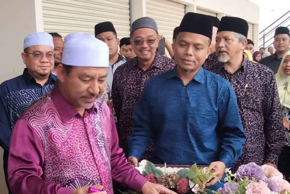 Hilmi (belakang, kiri) mengiringi Mohd Nassuruddin menyempurnakan Majlis Perasmian Bandar Baru Jelawat.