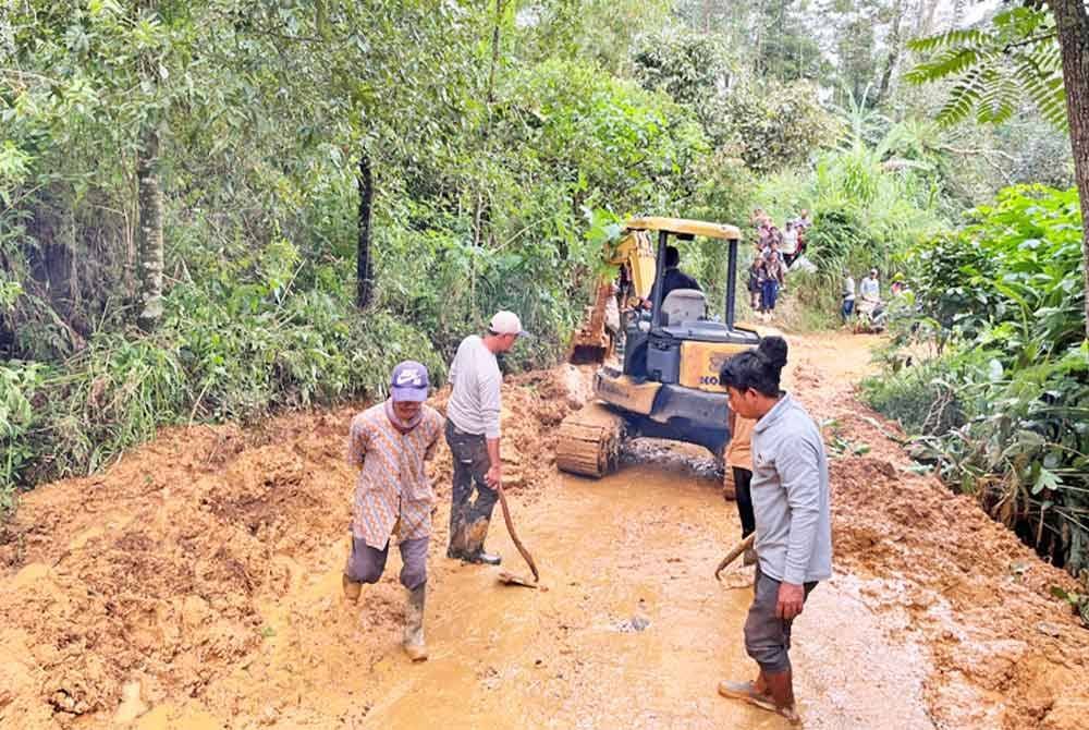 Pekerja membersihkan jalan yang terputus akibat kejadian tanah runtuh berikutan banjir kilat di Pekalongan, Jawa Tengah. Foto Agensi