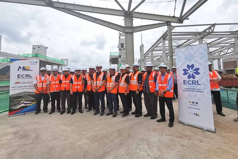 Ahmad Samsuri (tengah) merakam gambar ketika melawat kawasan tapak pembangunan berorientasi transit (TOD) di stesen Projek Laluan Rel Pantai Timur (ECRL) negeri itu.