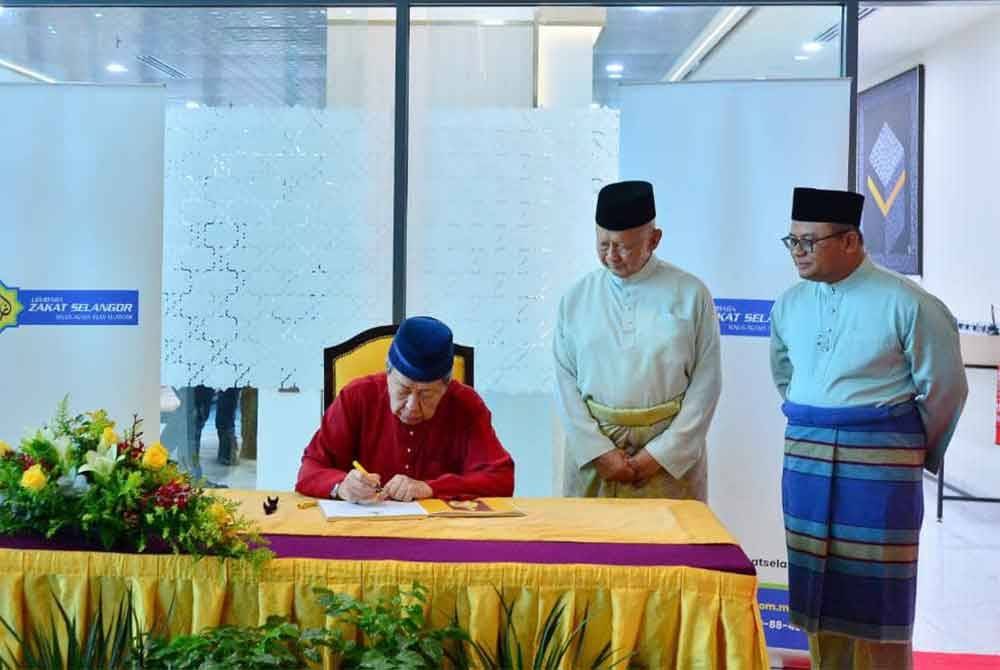 Sultan Sharafuddin (duduk) berkenan mencemar duli menandatangi buku tetamu rasmi dalam majlis perasmian Menara Zakat Sultan Idris Shah pada Khamis.
