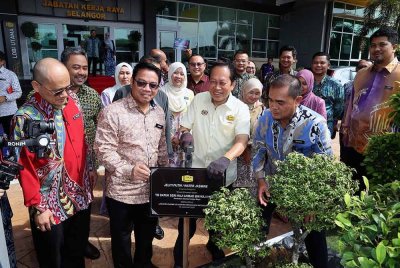 Ahmad (tengah) bersama Pengarah Jabatan Kerja Raya (JKR) Negeri Selangor, Ir Shukri Ishak (dua dari kiri) bergambar selepas menanam pokok sebagai simbolik lawatan kerja beliau di JKR Negeri Selangor di Shah Alam pada Khamis. - Foto Bernama