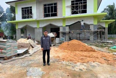 Kamalulnizam di hadapan surau yang sedang dalam pembinaan.