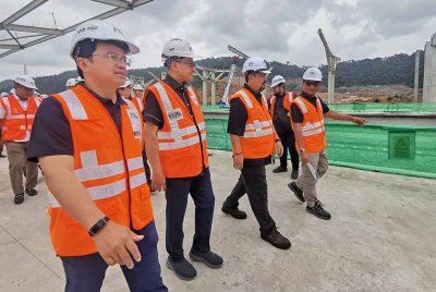 Darwis (kiri) bersama Ahmad Samsuri (dua dari kiri) meninjau kemajuan stesen ECRL Dungun.
