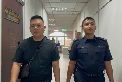 Tertuduh (kiri) ketika dibawa ke Mahkamah Butterworth pada Khamis.