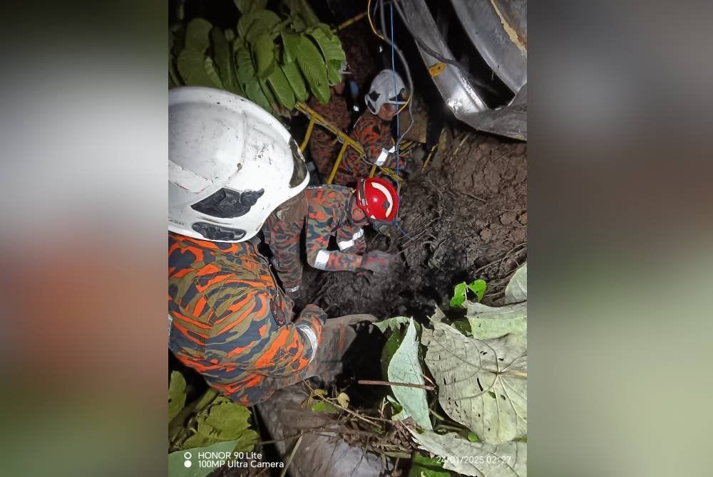 Anggota bomba mengorek timbunan tanah menggunakan peralatan khas untuk mengeluarkan mangsa.