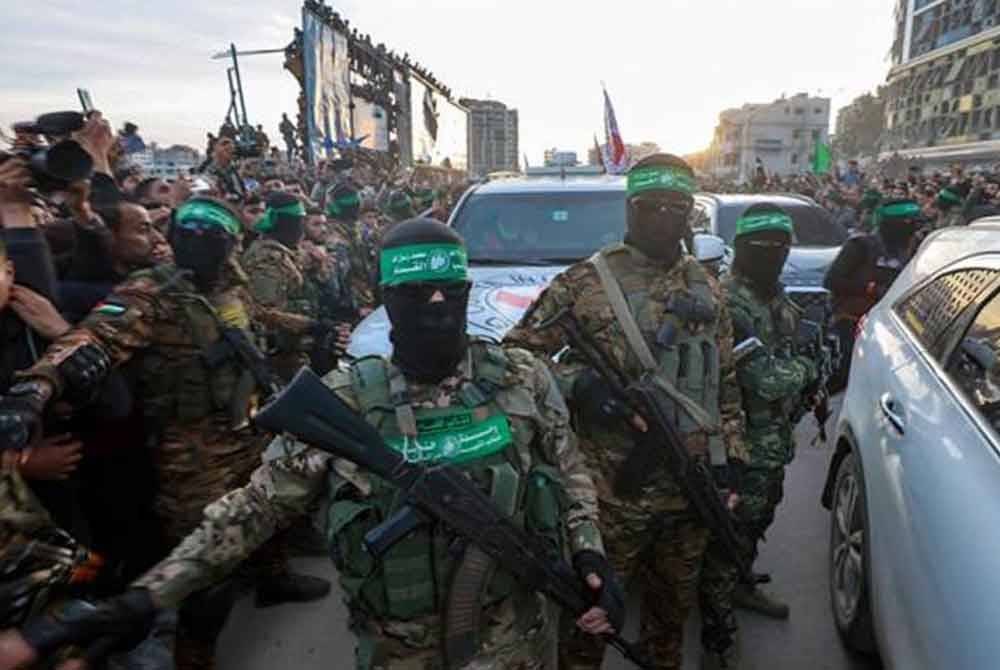 Pejuang Hamas mengiringi sebuah kenderaan Palang Merah untuk mengambil tebusan Israel yang dibebaskan selepas perjanjian gencatan senjata antara Israel dan Hamas mula berkuat kuasa pada 19 Januari 2025. Foto Agensi