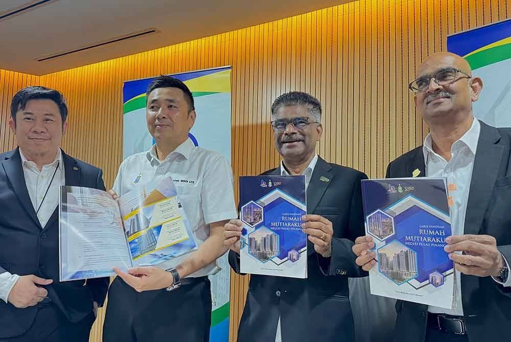 Sundarajoo (dua dari kanan) bersama Mooi Lye (dua dari kiri) dan Rajendran (kanan) menunjukkan buku garispanduan RMM Pulau Pinang.