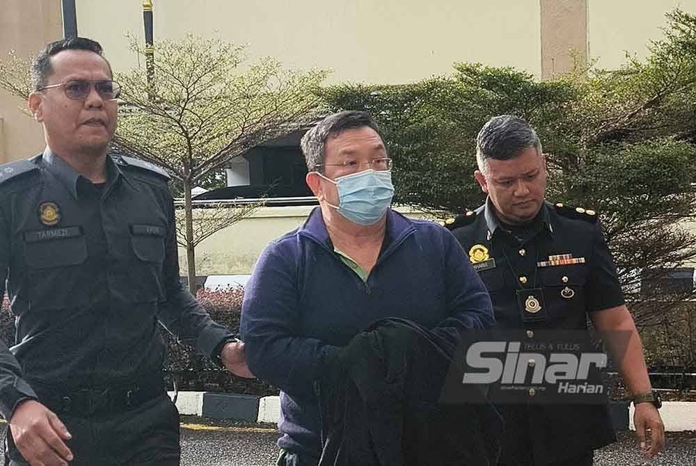 Sarn Yeun (tengah) memakai baju berkolar warna biru, dibawa ke Mahkamah Sesyen Petaling Jaya pada Jumaat, bagi menghadapi pertuduhan menggunakan logo halal dan cap dagangan tanpa kelulusan, pada pelbagai jenis sandwic, dua minggu lalu.