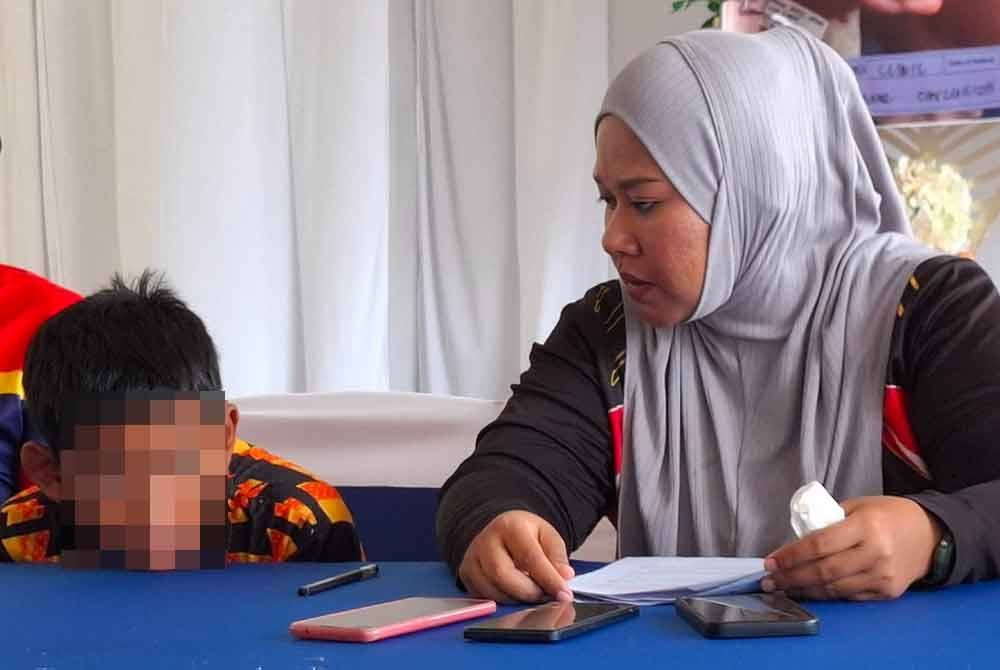 Syahmina merenung sayu anaknya semasa sidang akhbar pada Jumaat.