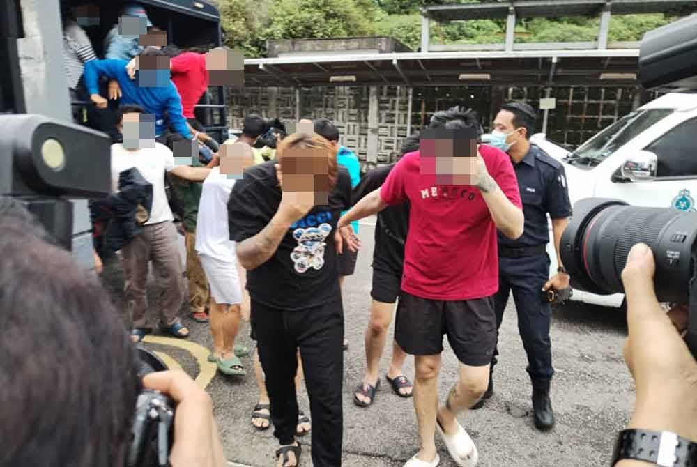 Tertuduh (dua hadapan) ketika tiba ke mahkamah pada Jumaat.