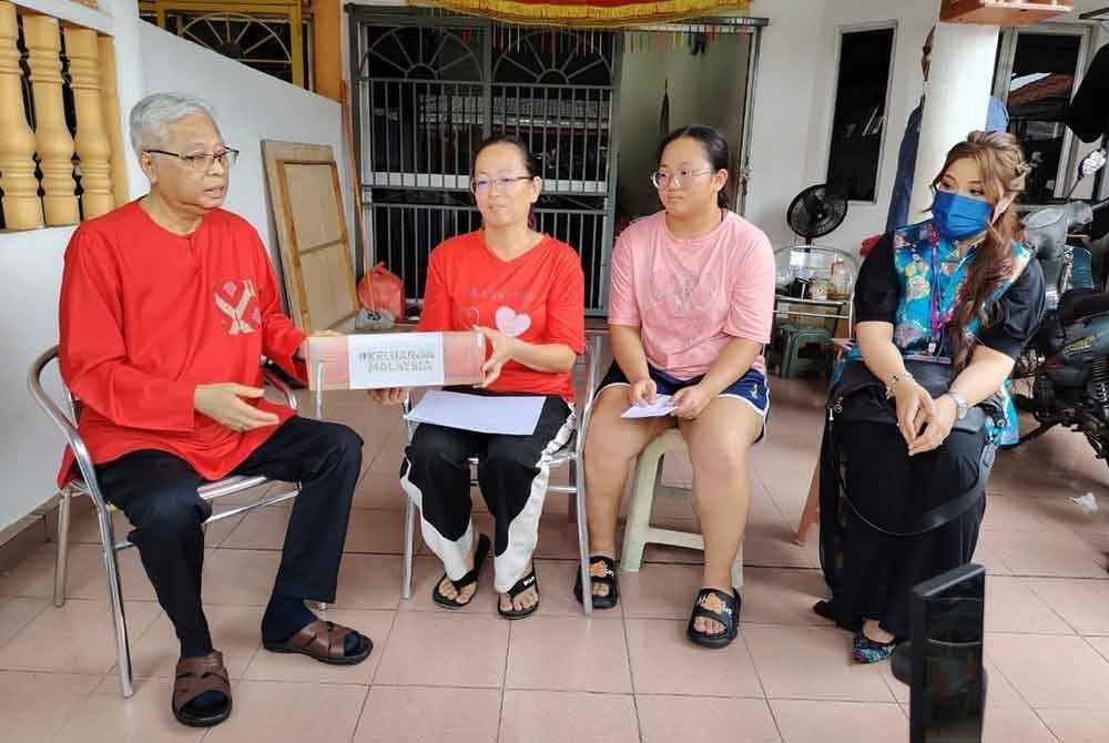 Ismail Sabri (kiri) ketika melawat Na Ai Tin (tiga dari kanan) di Taman Yayasan di Jenjarom di sini sempena program Ziarah Kasih pada Jumaat