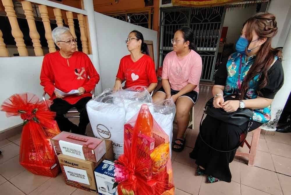 Ismail Sabri (kiri) ketika melawat keluarga Na Ai Tin, 43, di Taman Yayasan di sini sempena program Ziarah Kasih.