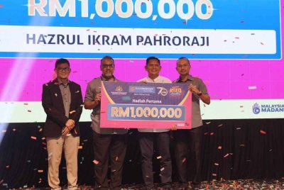 Mohd Irwan (dua dari kiri) menyampaikan hadiah utama, RM1 juta kepada Hazrul Ikram disaksikan Ahmad Shahri (kanan) dan Nor Haimee (kiri).