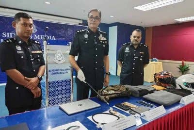 Balveer (tengah) menunjukkan antara barang curi yang dirampas daripada suspek.