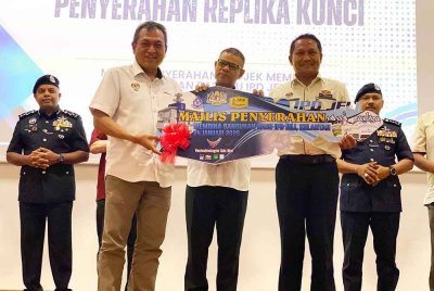 Saifuddin Nasution (tengah) semasa menyaksikan penyerahan replika kunci pada Majlis Penyerahan Projek Membina Bangunan Baharu Ibu Pejabat Polis Daerah (IPD) Jeli pada Jumaat.