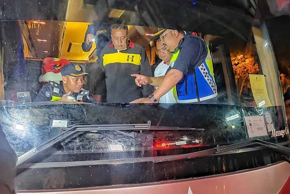 Hameed (dua dari kiri) melihat anggota penguat kuasa melakukan pemeriksaan teknikal terhadap kenderaan berat itu di Melaka Sentral di sini, pada malam Jumaat.