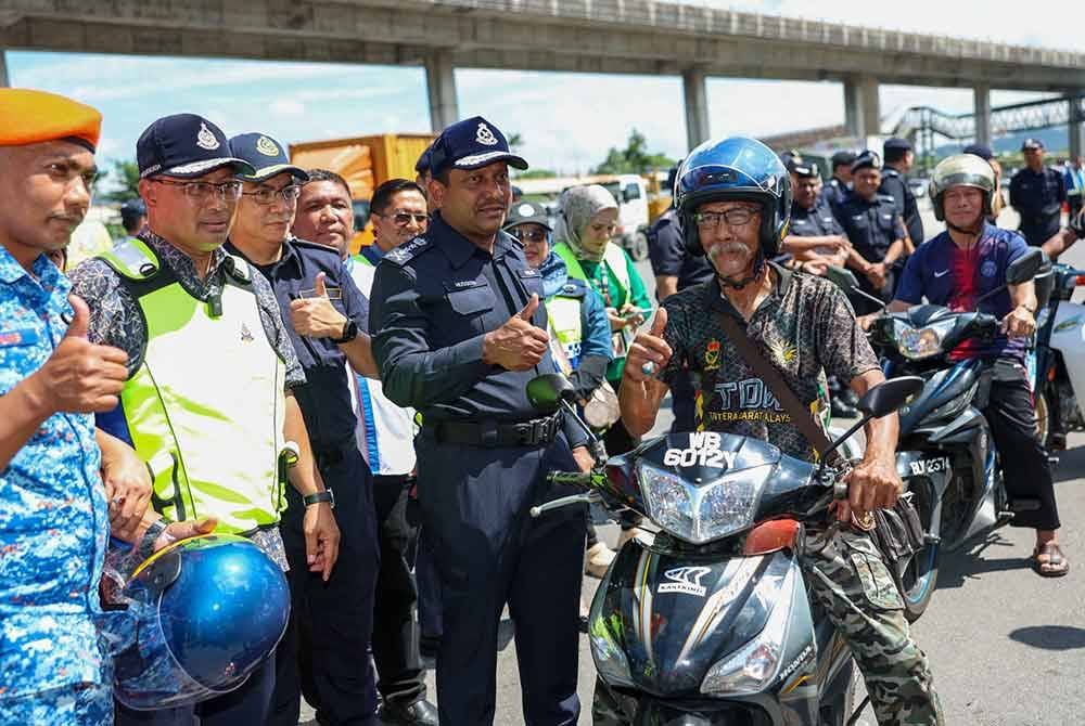 Hussein (depan, dua dari kanan) menunjukkan tanda bagus semasa majlis pelancaran kempen keselamatan jalan raya dan advokasi sempena perayaan Tahun Baharu Cina di Plaza Tol PJS 2, Lebuhraya NPE, Petaling Jaya, Selangor pada Sabtu. - Foto: Bernama