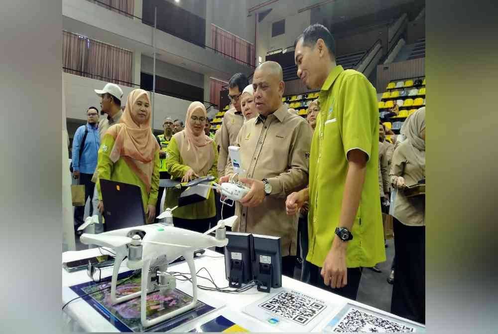 Saarani (dua dari kanan) turut mencuba penggunaan dron sempena Program Hari e-Tanah Negeri Perak di Stadium Indera Mulia, Ipoh pada Sabtu.