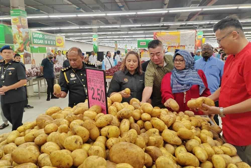 Norena (dua dari kiri) Tuminah (empat,kiri) dan Seah Shoo Chin melihat kentang dari negara China yang dipamerkan tanda harga berwarna merah jambu