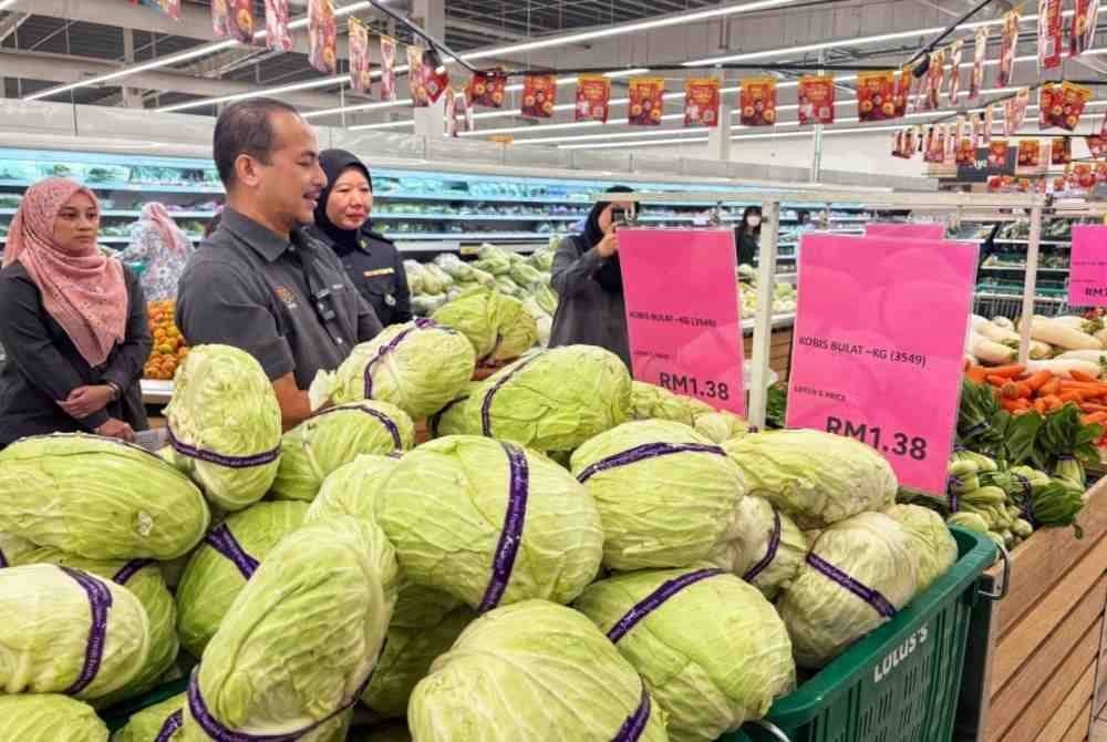 Muhammad Nizam memeriksa barangan yang dikawal sempena Tahun Baharu Cina di sebuah pasar raya di sini pada Sabtu.