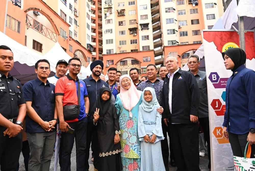Wan Azizah bergambar dengan penduduk setempat selepas merasmikan PADI Desa Tun Razak, pada Sabtu. Foto SKMM