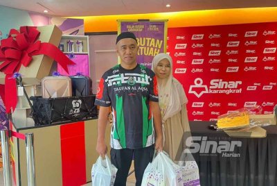 Mazianudin (kiri) bersama isteri tidak melepaskan peluang membeli bahan bacaan dengan harga diskaun sempena Jualan Gudang Karangkraf 2025.
