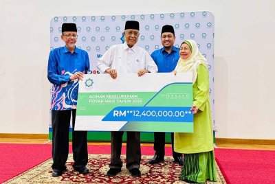 Abdul Aziz (dua dari kiri) memegang replika cek sasaran agihan sumbangan fidyah pada tahun ini.